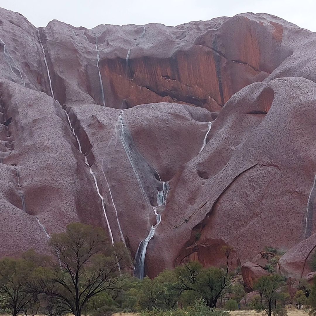Waterfalls on Uluru after outback soaking, more rain to come